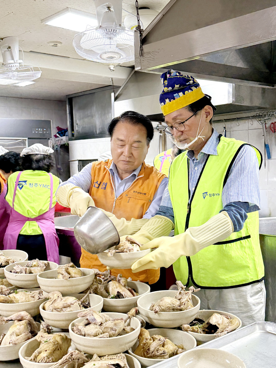 이성희 청주상당신협 이사장이 최충진 이사장이 어르신들께 나눌 삼계탕을 담고 있다.