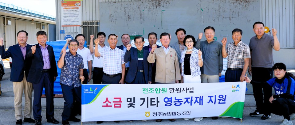 ▲ 이화준 청주농협 조합장(앞줄 가운데)과 임직원들이 월동 준비용 소금을 전달한 뒤 조합원들과 함께 기념촬영을 하고 있다.