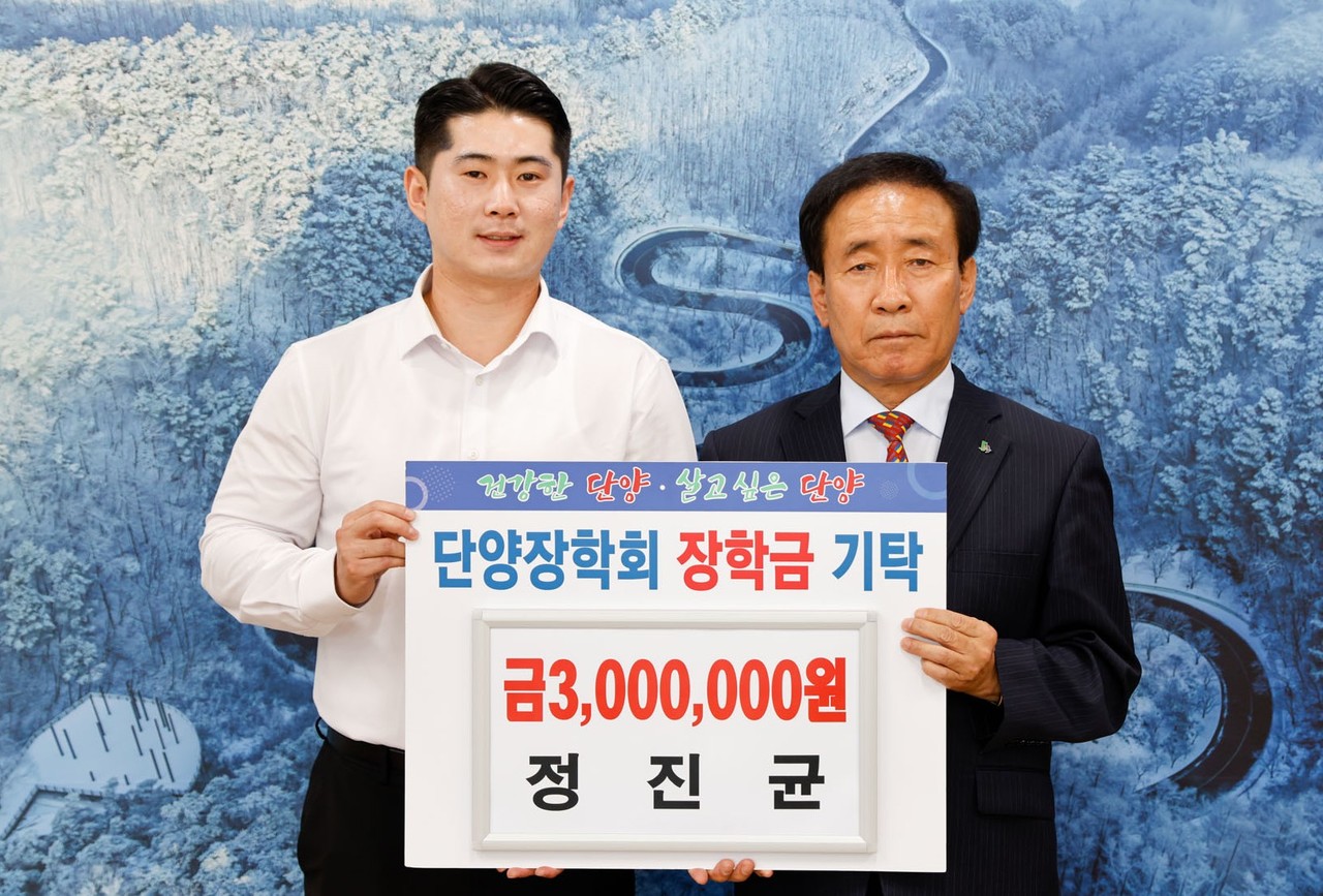 ▲ 단양신협 정진균씨(왼쪽)가 김문근 군수에게 장학금을 전달하고 있다. 사진=단양군제공