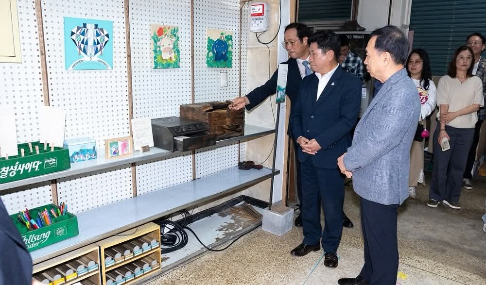 ▲ 제천중앙시장 작은도서관 개관식에서 김창규 시장(가운데)과 김상수 재단 이사장(오른쪽)이 전시 작품을 살펴보고 있다. 사진=제천시제공