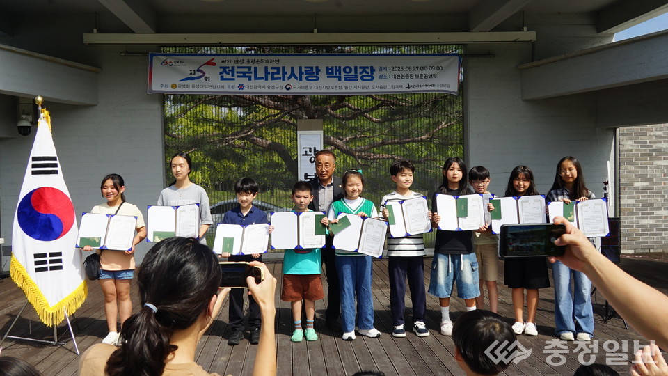 ▲ 백일장에서 수상한 학생들이 김영우 광복회 유성대덕연합지회장과 함께 기념사진을 찍고 있다. 아이들은 직접 쓴 작품을 들고 무대에 올라 나라사랑의 의미를 되새겼다
