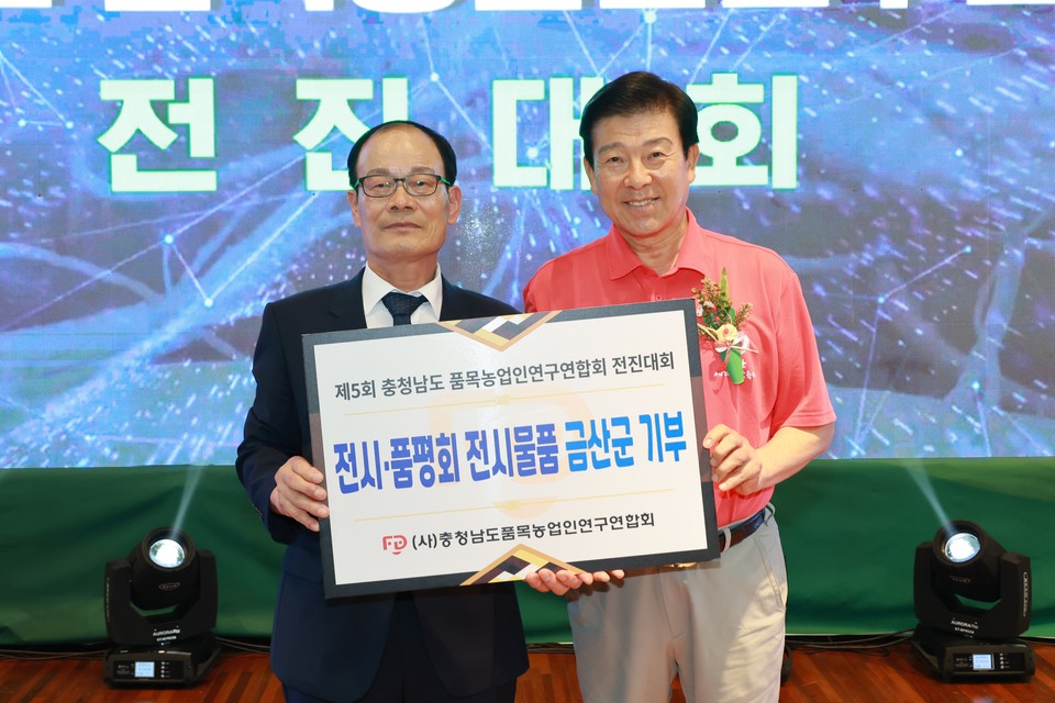 ▲ 명헌식 품목농업인연구연합회장(왼쪽)이 박범인 군수에게 행사 전시물품을 전달하고 있다./금산군 제공