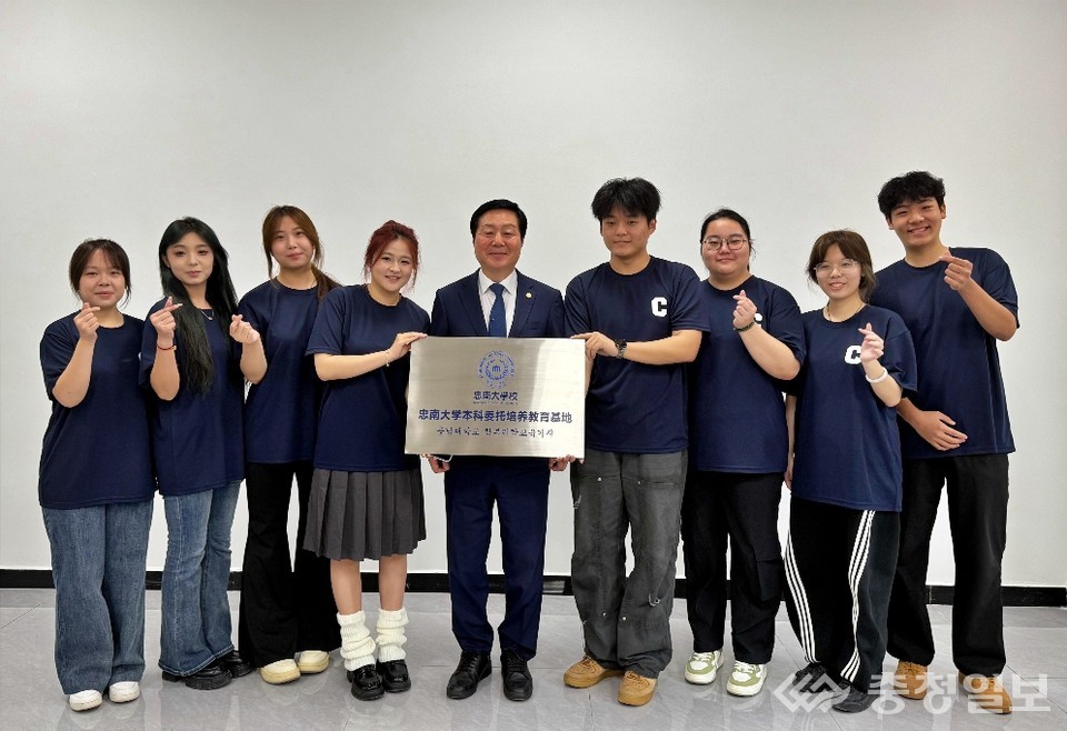 ▲ 충남대학교 김정겸 총장이 시안외국어대학교에서 열린 ‘1+3 학부위탁교육기지 현판식’에서 학생들과 함께 현판을 들고 자리를 함께하고 있다. 모두가 환한 표정으로 서 있으며, 충남대의 중국 현지 교육 기지 설립을 알리는 뜻깊은 순간을 보여준다.