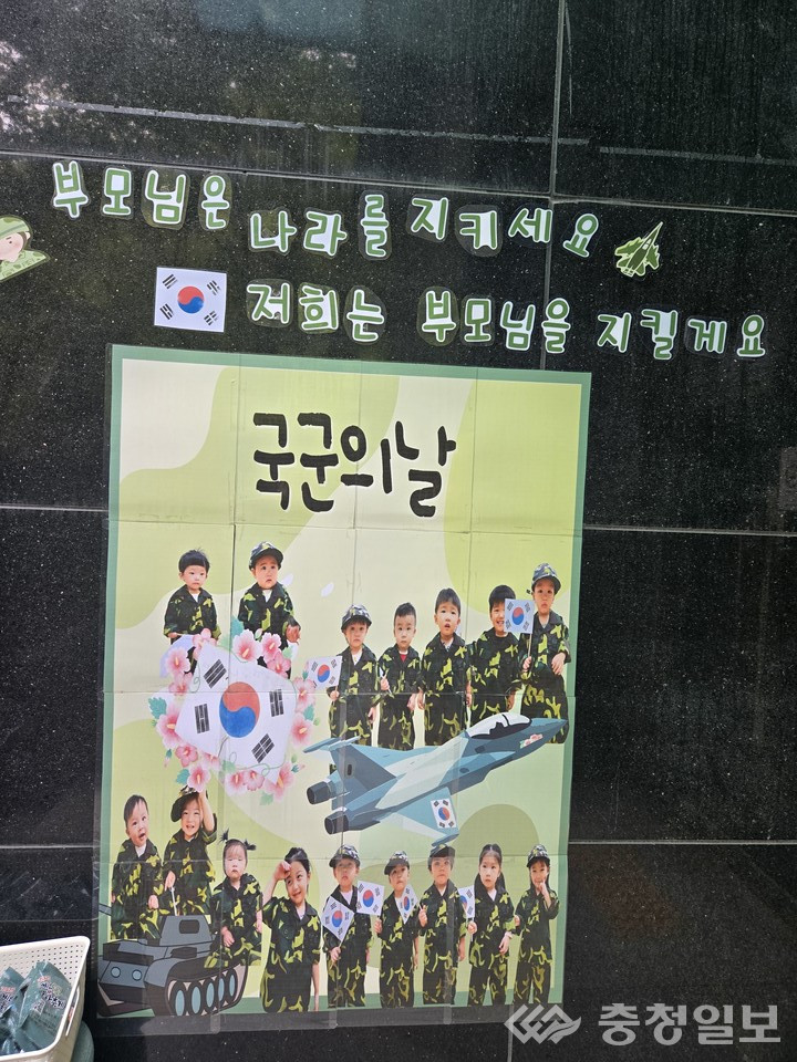 ▲ 국군의 날을 맞아 스마트시티 어린이집 원생들이 군복을 입고 태극기를 들며 포즈를 취한 모습. ‘부모님은 나라를 지키세요, 저희는 부모님을 지킬게요’라는 문구와 함께 꾸며진 포토존 앞에서 아이들이 미래의 작은 수호자가 된 듯 밝게 서 있다