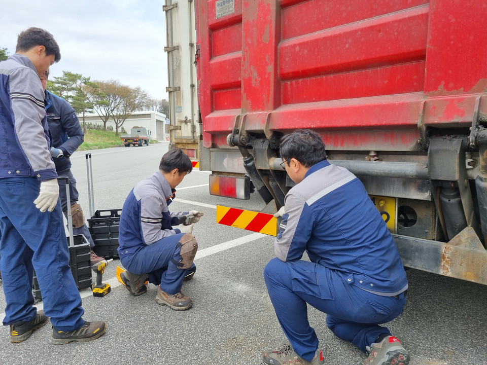 ▲ 한국도로공사 충북본부 직원들이 음성휴게소에서 화물차 대상 후부 반사판 부착 등 교통안전 캠페인을 하고 있다.
