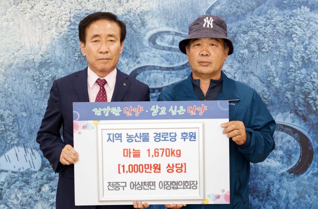 ▲ 전중구 단양군 어상천면 이장협의회장(오른쪽)이 김문근 군수에게 마늘을 전달하고 있다. 사진=단양군제공