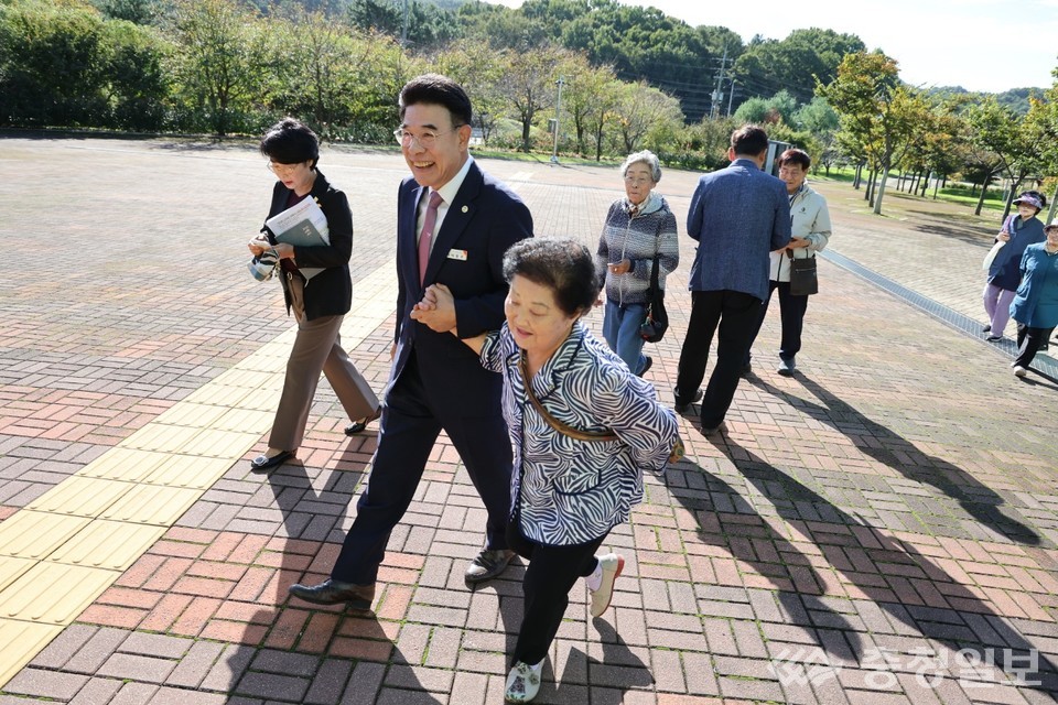 ▲ 이응우 계룡시장(사진 앞줄 가운데)이 15일 계룡문화예술의전당에서 열린 ‘29회 노인의 날 기념행사’에 참석한 어르신의 손을 잡고 함께 거닐며 환하게 웃고 있다