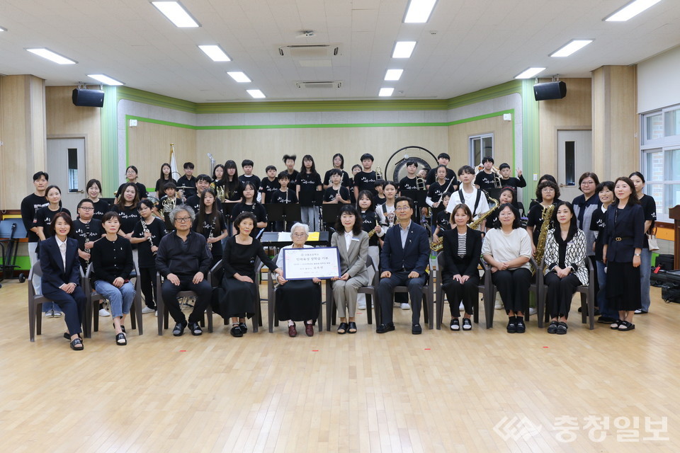 ▲ 산흥초등학교에서 열린 장학금 기탁식에서 중앙 왼쪽 김옥연 할머니가 기탁서를 전달하고 있다. 오른쪽은 원정애 교장. 행사에는 학생들과 교직원이 함께 참석해 따뜻한 마음을 나눴다. 사진=산흥초등학교 제공