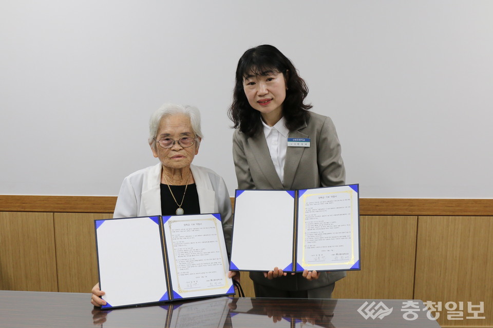▲ 산흥초등학교 김옥연(왼쪽) 할머니가 학교발전기금 기탁서를 원정애 교장(오른쪽)에게 전달하고 있다. 평생 이웃에게 따뜻한 식사를 나눠온 김 할머니는 앞으로 6년간 후배 학생들을 위한 장학금을 지원하기로 약속했다