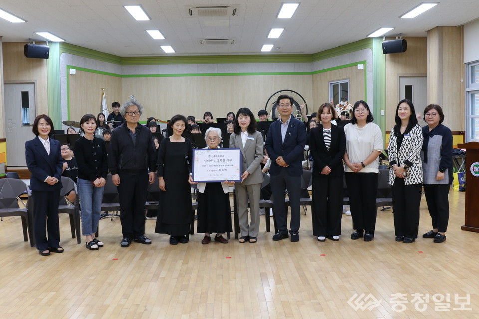 ▲ 산흥초등학교 김옥연(가운데) 할머니가 원정애 교장(오른쪽 다섯 번째)에게 장학금 기탁서를 전달한 뒤 관계자들과 함께했다