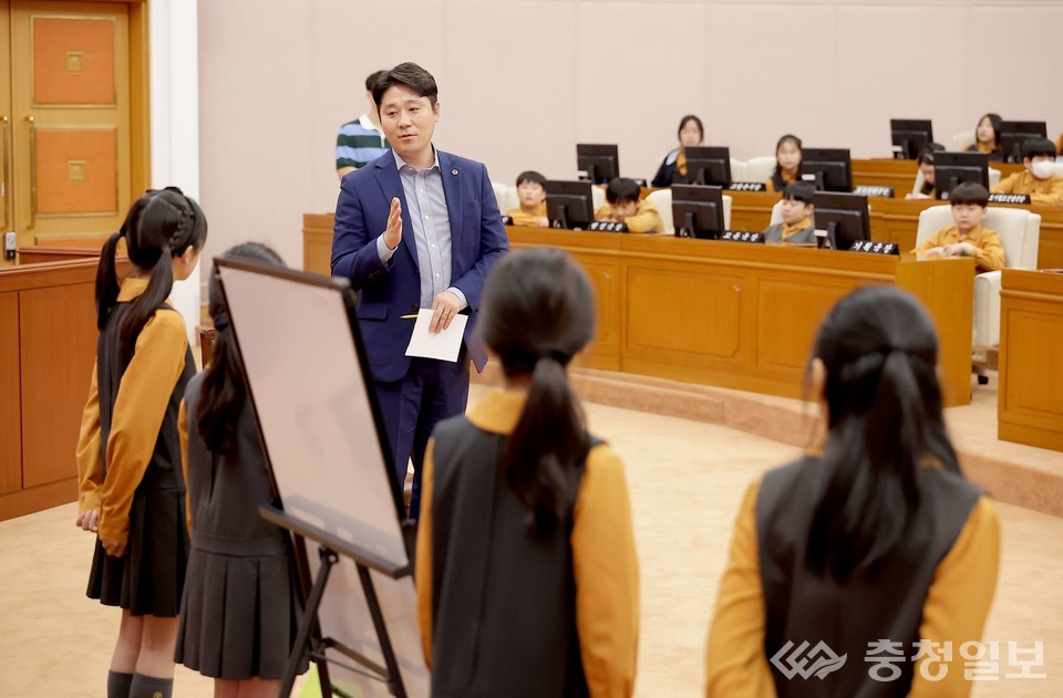 ▲ 김진오 의원이 학생들에게 의정활동과 지방자치의 의미를 설명하며 대화를 나누고 있다. 학생들은 의원석에 앉아 진지하게 경청하고 있다