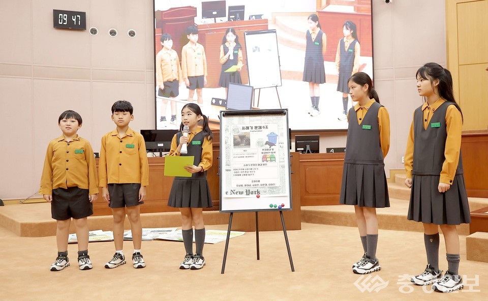 ▲ 학생들이 14일 대전시의회 본회의장에서 모의 의정활동을 진행하며 쓰레기 문제 해결 방안을 발표하고 있다. 학생들이 직접 작성한 자료를 보드에 붙여 설명하고 있으며, 뒤편 스크린에는 발표 장면이 실시간으로 비춰지고 있다