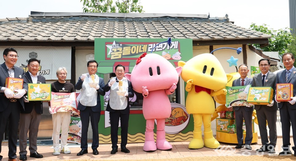 ▲ 이장우 대전시장을 비롯한 관계자들이 대전엑스포과학공원 내 ‘꿈돌이네 라면가게’ 앞에서 대전 로컬브랜딩 첫 상품인 ‘꿈돌이 라면’을 홍보하고 있다. 가운데 분홍색과 노란색 캐릭터는 대전의 상징 ‘꿈씨패밀리’의 꿈순이와 꿈돌이.