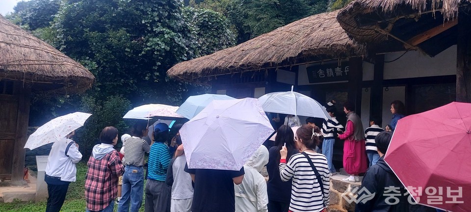 ▲ 참가자들이 비가 내리는 가운데 신채호 선생 생가를 방문해 해설을 들으며 독립운동가의 뜻을 되새기고 있다