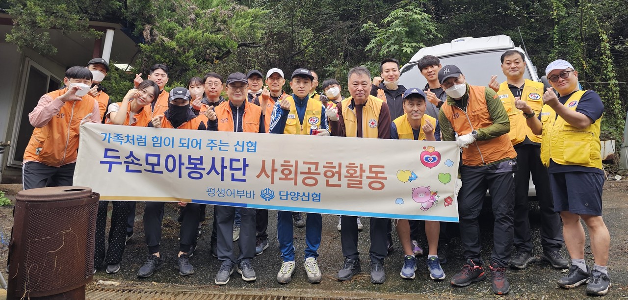 ▲ 지난 19일 단양신협과 적십자단양봉사회원들이 매포읍 우덕리에서 집수리 봉사를 마치고 사진촬영을 하고 있다. 사진=단양신협제공