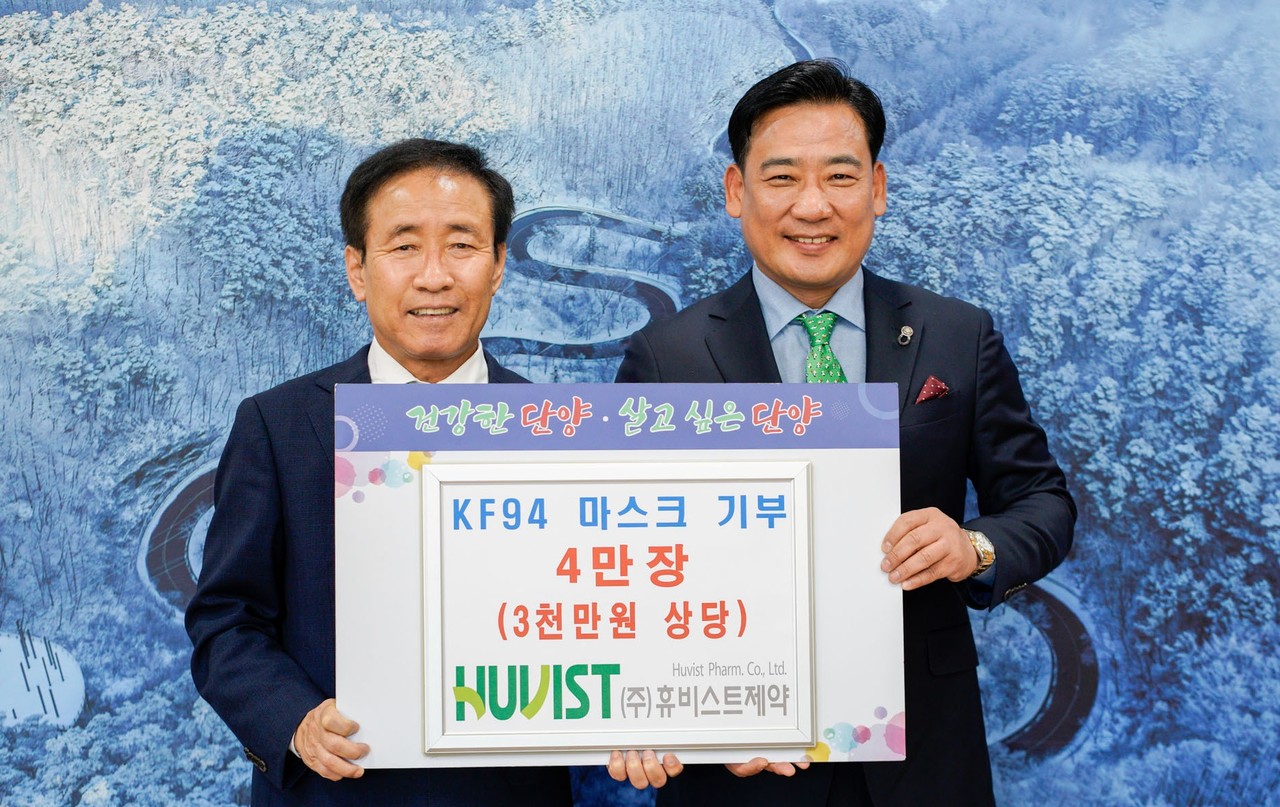 ▲ ㈜휴비스트제약 박광남 대표(오른쪽)가 김문근 군수에게 마스크를 전달하고 있다. 사진=단양군제공