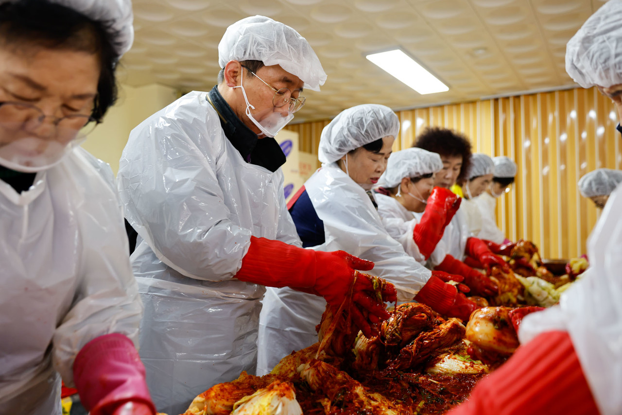 ▲ 김문근 군수(왼쪽 두 번째)가 단양군여성단체협의회원들과 이웃에 전달할 김치를 버무리고 있다. 사진=단양군제공