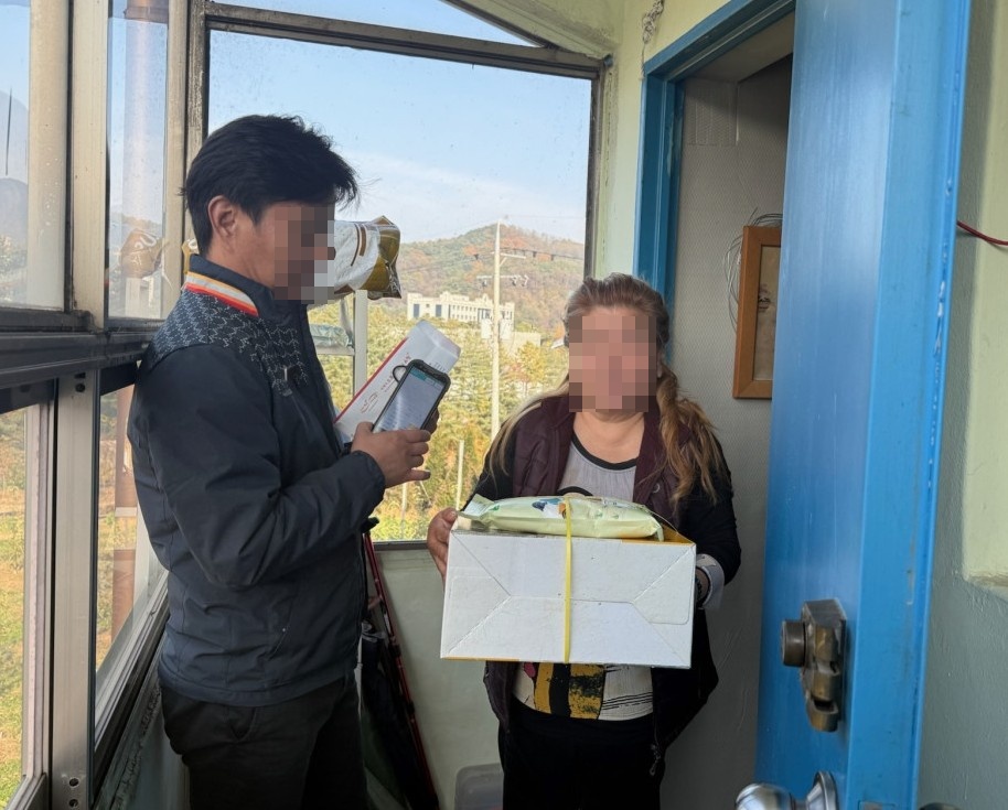 ▲ 제천우체국 우편집배원(왼쪽)이 대상 가구에 생필품을 전달하고 있는 모습. 사진=제천시제공