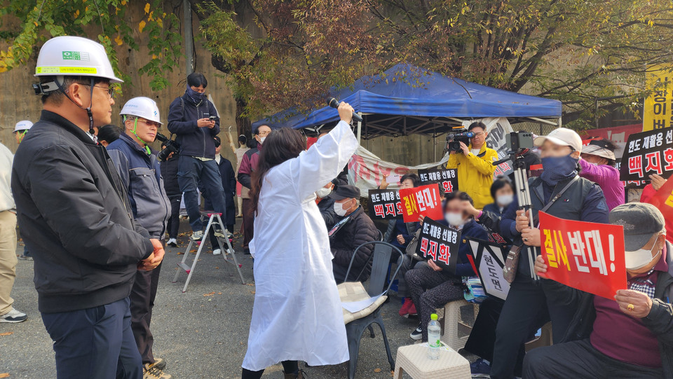 지난 7일 충북 청주시 현도면 재활용선별센터 건립 부지 앞에서 시공사 관계자가 주민들을 설득하고 있다.