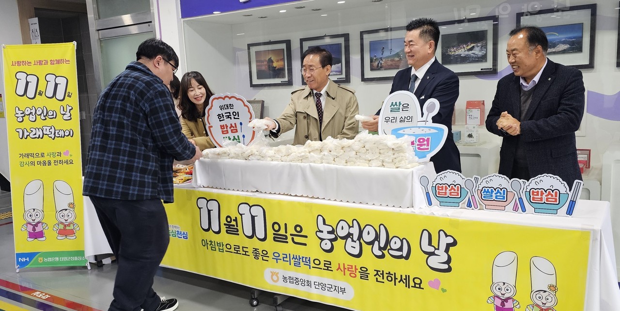 ▲ 11일 농협 단양군지부가 제29회 농업인의 날을 맞아 단양군청에서 김문근 군수와 함께 출근하는 직원들에게 가래떡을 나눠주고 있다. 사진=농협단양군지부제공