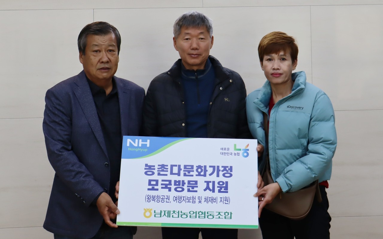 ▲ 류승인 남제천농협 조합장(왼쪽)이 조합원 이대희씨 가족에게 처가를 다녀올 수 있는 항공권 등을 전달하고 기념촬영을 하고 있다. 사진=남제천농협제공