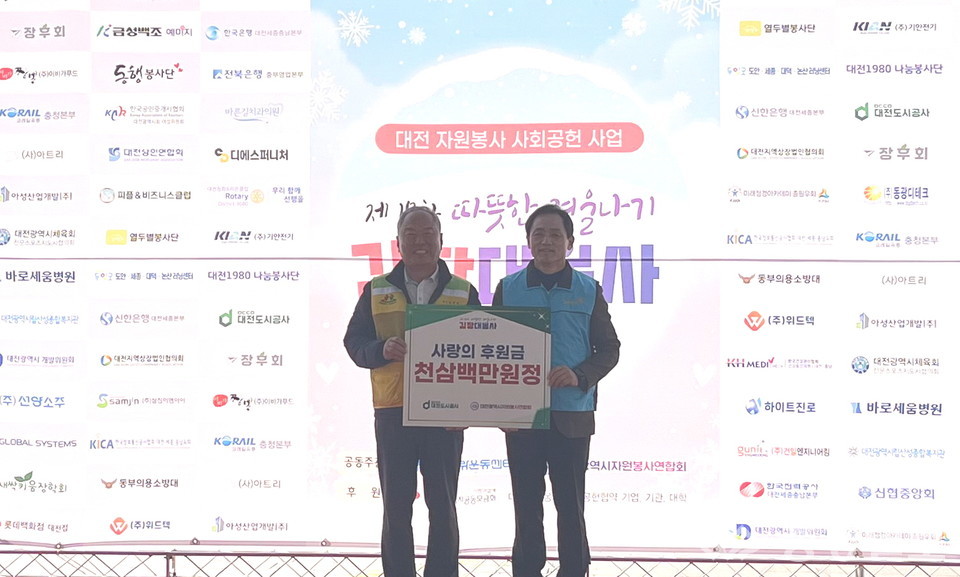 ▲ 왼쪽부터 김영태 대전시자원봉사연합회 회장, 정국영 대전도시공사 사장이 12일 엑스포 남문광장에서 열린 ‘따뜻한 겨울나기 사랑의 김장대봉사’ 행사에서 후원금 1300만원을 전달한 뒤 기념촬영을 하고 있다