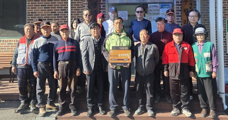 ▲ ‘소각 산불 없는 녹색마을 만들기’ 우수마을에 선정된 단성면 두항리 주민들이 현판식에 앞서 기념촬영을 하고 있다. 사진=단양군제공