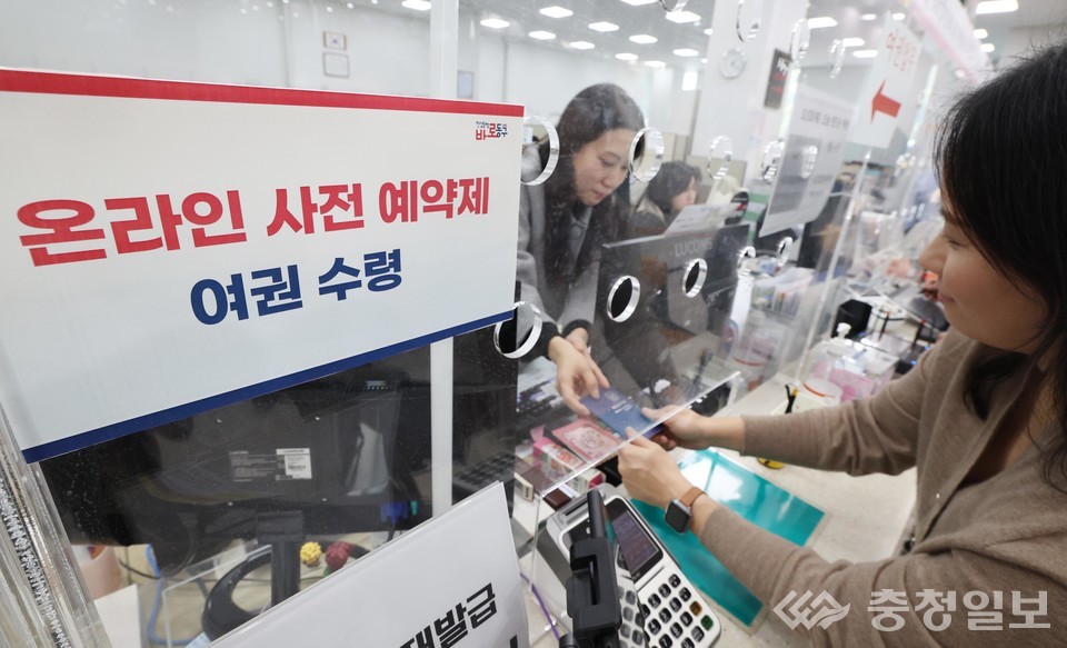 ▲ 동구청 민원창구에서 온라인 사전 예약제로 발급된 여권을 창구 직원이 민원인에게 전달하고 있다