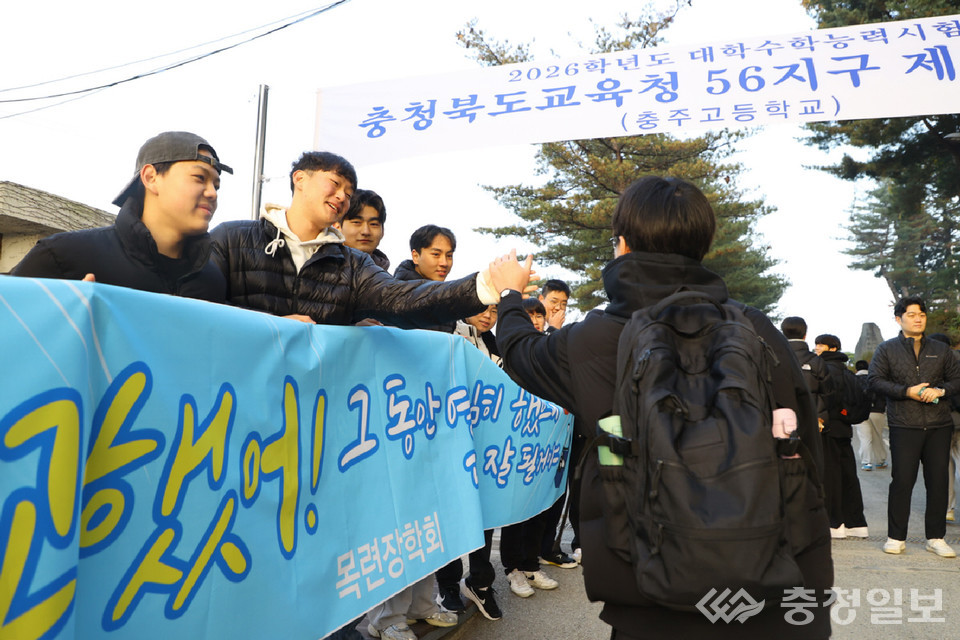 ▲ 13일 충주고등학교 정문 앞에서 선후배들이 시험장에 들어가는 수험생의 손을 잡으며 응원하고 있다.