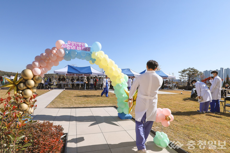 ▲ 유성선병원 의료진이 14일 본관 5층 옥상 정원에서 열린 ‘사랑의 바자회’ 행사장을 향해 걸어가고 있다. 행사장 입구에는 풍선 아치와 판매 부스가 마련돼 지역 나눔 행사 분위기를 더했다