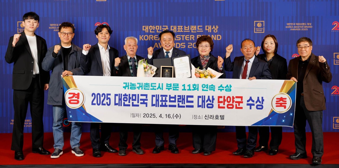 ▲ 단양군의 귀농귀촌 정책이 올해까지 11년 연속 대한민국 대표브랜드 대상을 받고 관계자들이 기념촬영을 하고 있는 모습. 사진=단양군제공