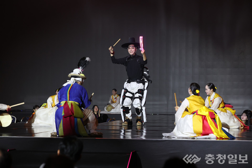 ▲ 미래형 K-컬처의 가능성을 상징적으로 보여주는 개막 퍼포먼스 장면. 전통무용수들 사이에서 한 퍼포머가 웨어러블 로봇을 착용한 채 무대를 이끌고 있으며, 기술과 예술의 움직임이 한 호흡으로 맞물리며 새로운 형태의 융합 공연을 펼치고 있다