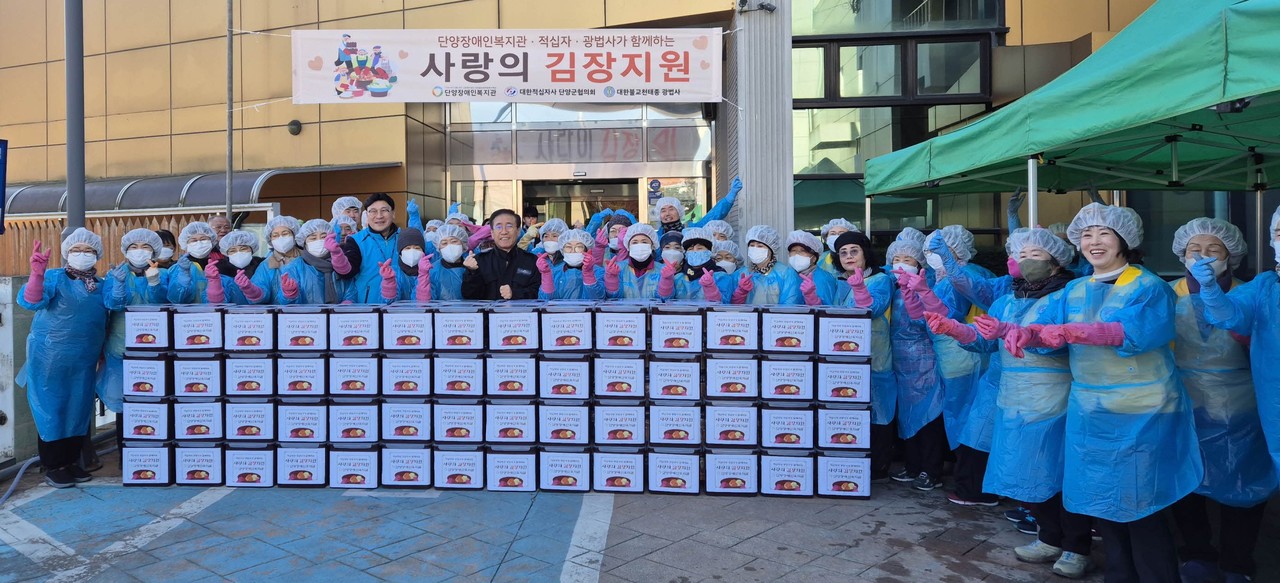 ▲ 단양장애인복지관에서 진행된 김장 나눔 행사에 참여한 자원봉사자들이 전달에 앞서 사진촬영을 하고 있다. 사진=단양군제공