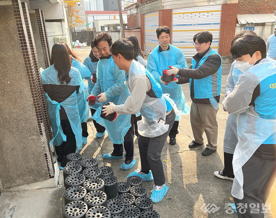 ▲ 직원들이 연탄을 손에서 손으로 건네며 취약가정의 겨울 준비를 돕고 있다