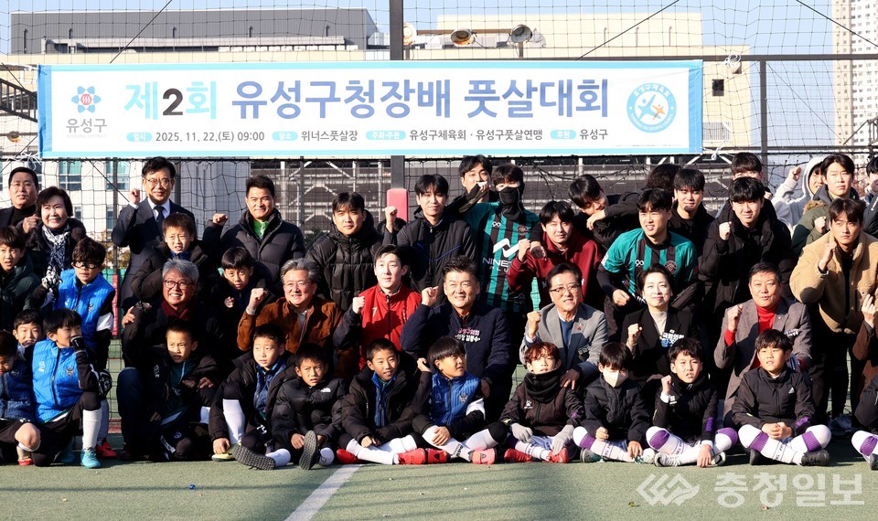 ▲ 풋살대회 현장에서 선수단과 내빈, 학부모 등이 함께 기념 촬영을 하고 있다. 어린 선수들의 밝은 표정과 팀 유니폼, 그리고 뒤편 현수막이 대회의 분위기를 보여준다