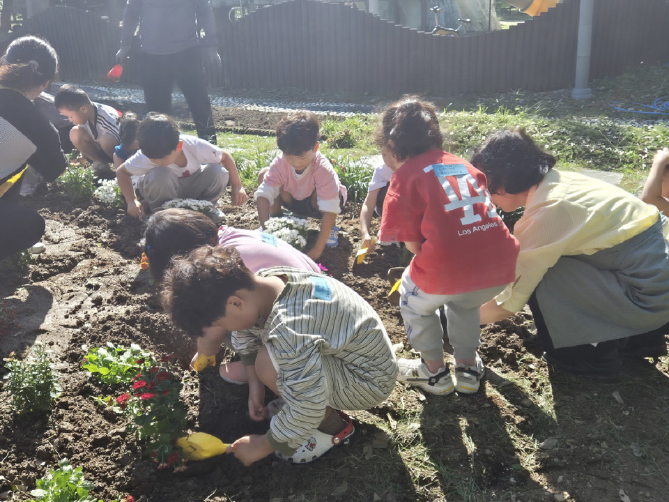 ▲ 　아이들이 정원에서 가을 꽃을 심는 체험을 하고 있다.