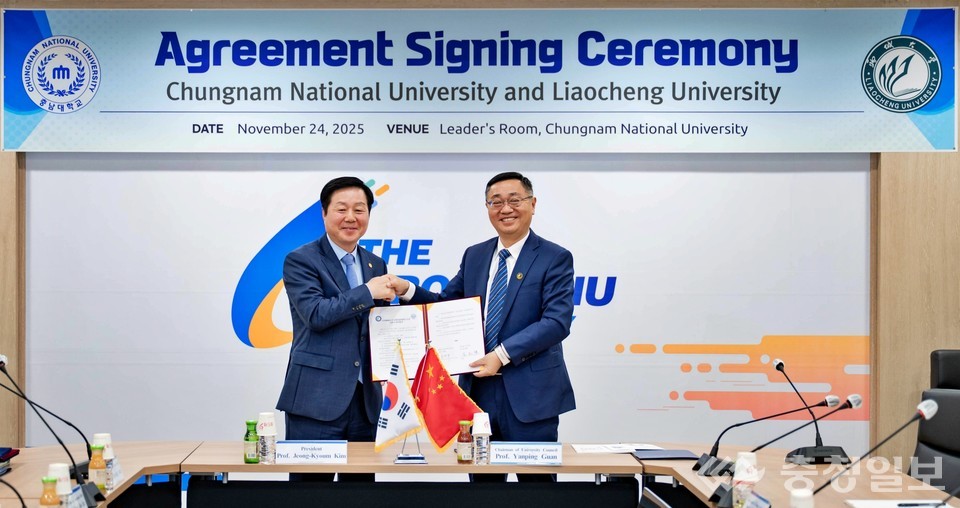 ▲ 충남대학교 리더스룸에서 충남대와 랴오청대학교 두 대학 총장이 교환학생협정 서류를 함께 들어 보이며 체결 사실을 공식적으로 확인하는 모습