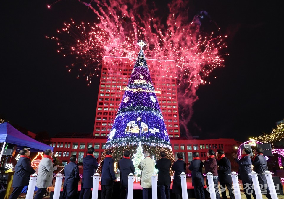 ▲ 대전시청 남문광장에서 높이 세워진 대형 성탄트리가 불을 밝히는 순간 뒤편 하늘에서 붉은 불꽃이 힘차게 터지며 시민들과 참석자들이 점등식을 지켜보고 있다