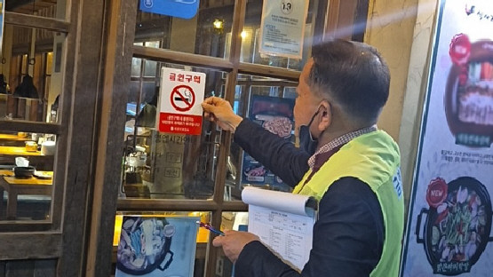 ▲ 금연지도원이 금연구역에서 흡연행위 여부를 단속하는 모습.